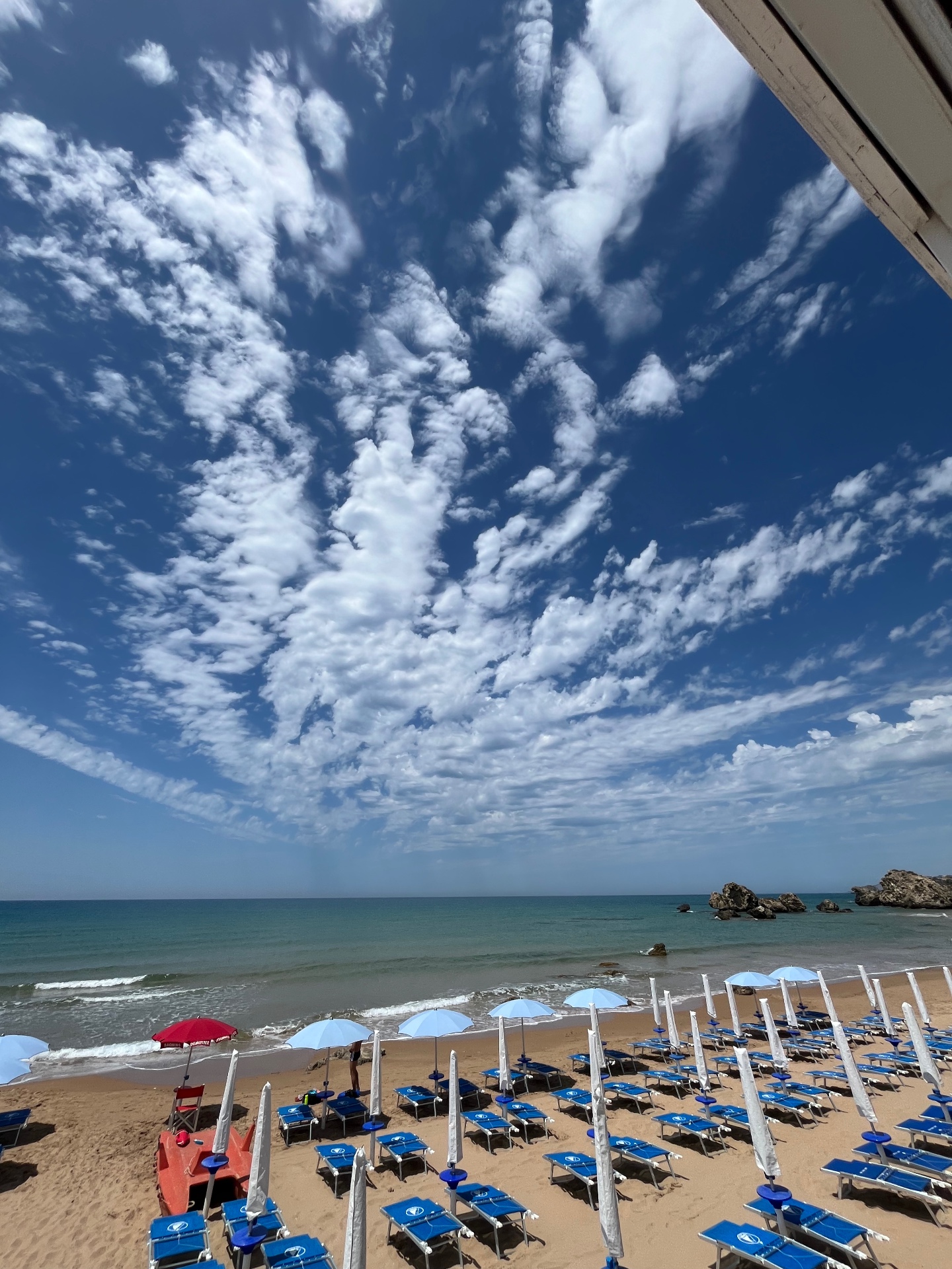 Spiaggia di giorno con cielo e nuvole sopra il mare
